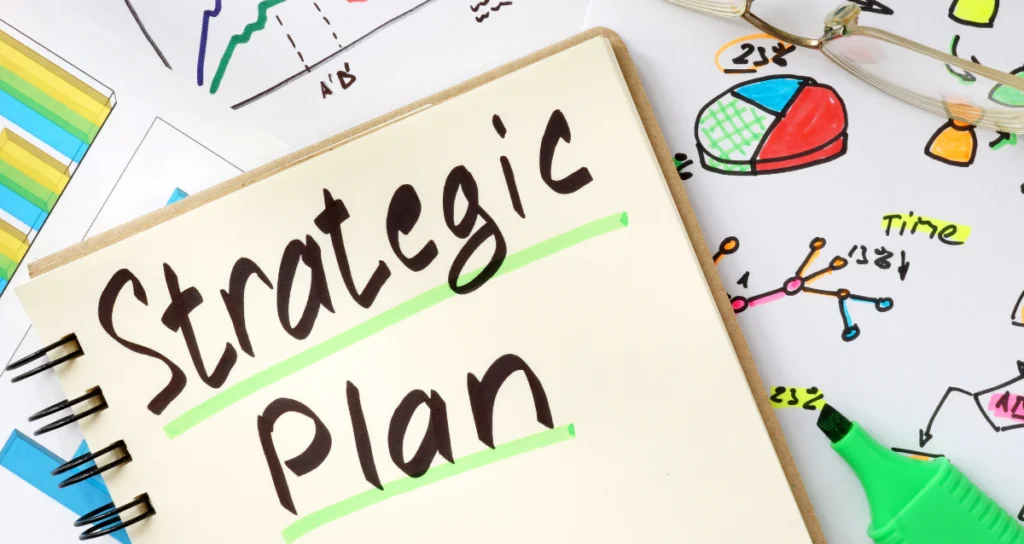 Colorful image of a notebook reading Strategic Plan on top of sketches of different types of charts and graphs