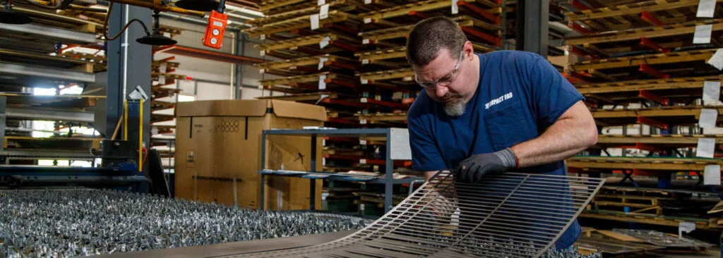 Impact Fab employee working on laser cutting