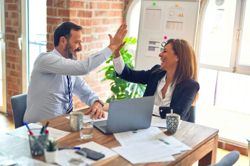 Two middle-aged business workers smiling, happy, and confident.