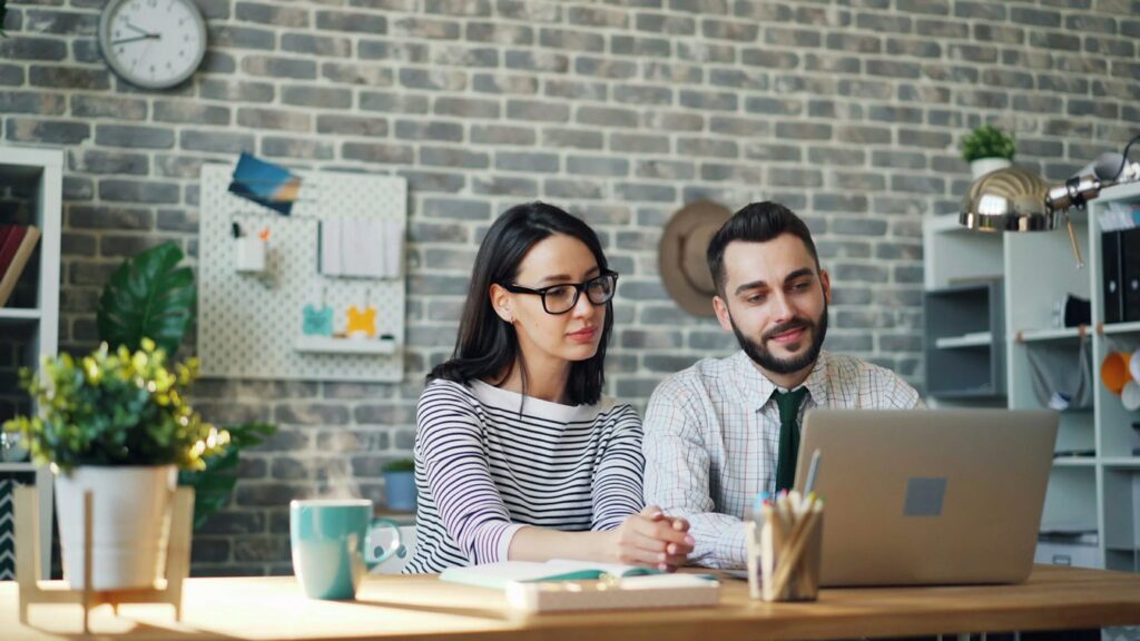 two young professionals looking at a laptop