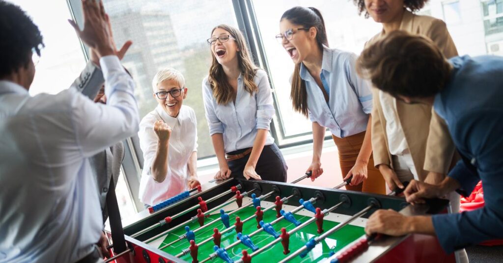 coworkers playing foosball