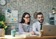 two young professionals looking at a laptop